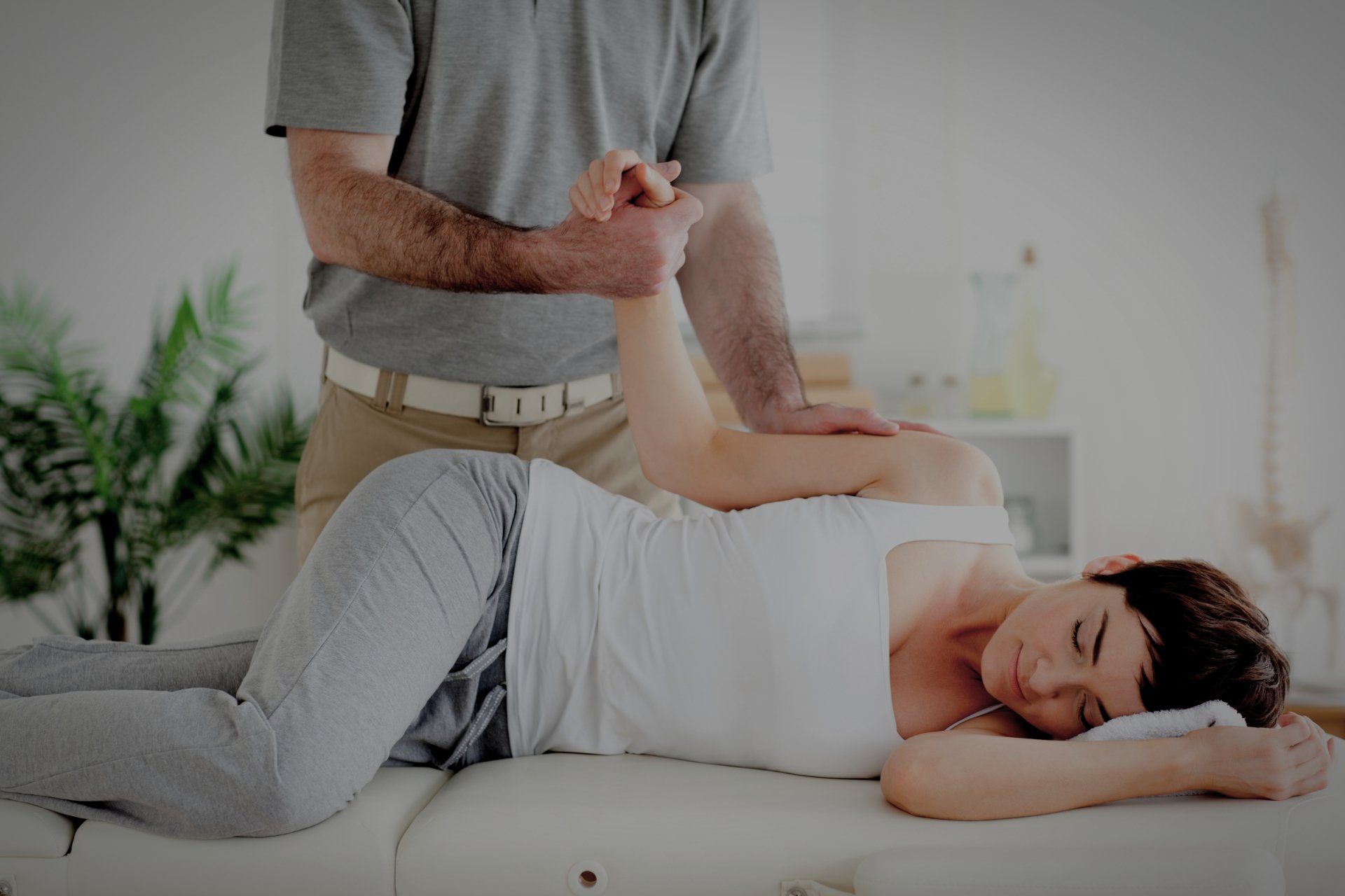 Eine Frau liegt auf einem Tisch und wird von einem Mann massiert.