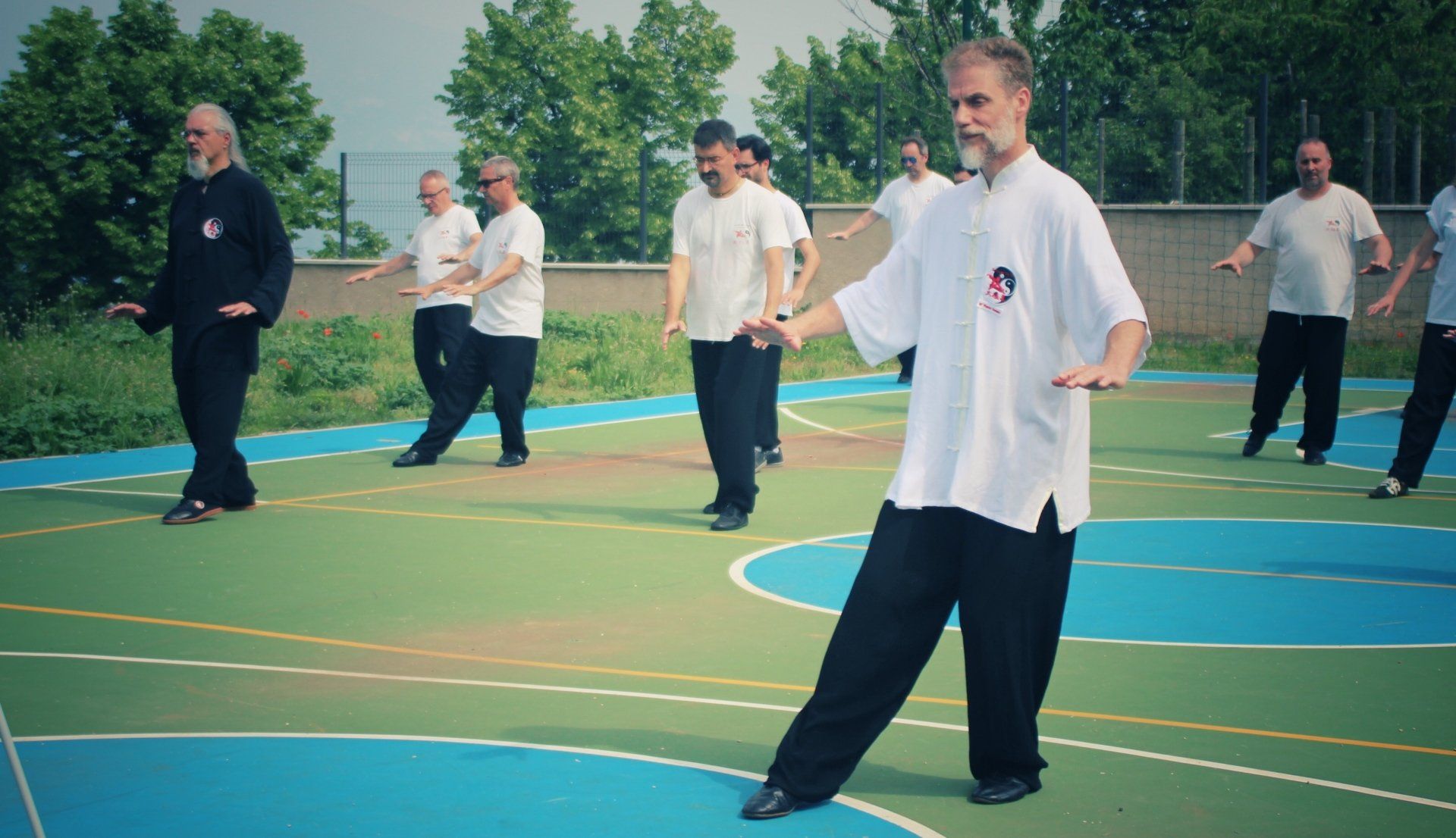 Un gruppo di uomini pratica arti marziali su un campo da basket.