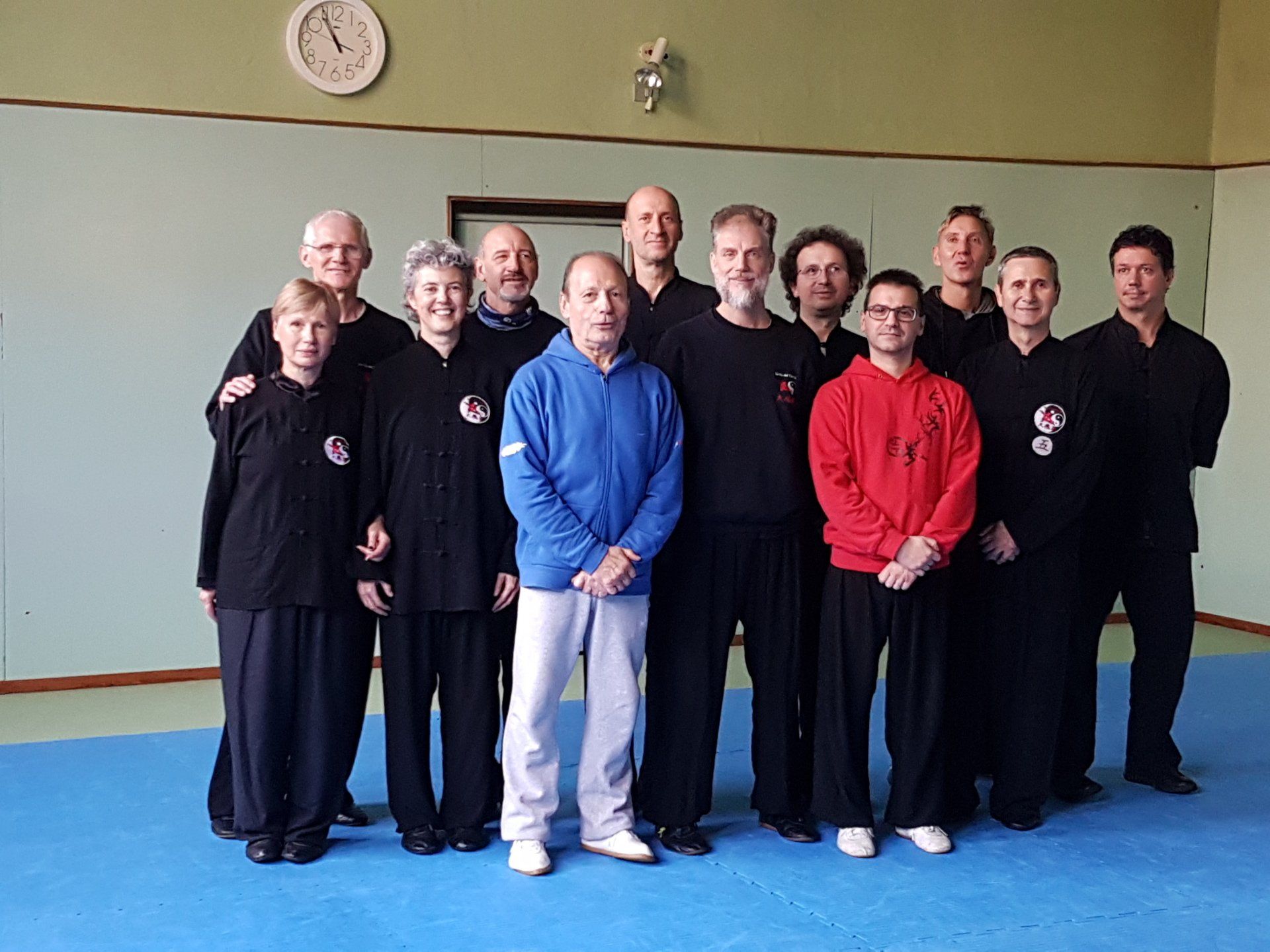Un gruppo di persone in posa per una foto in una stanza con un orologio sul muro