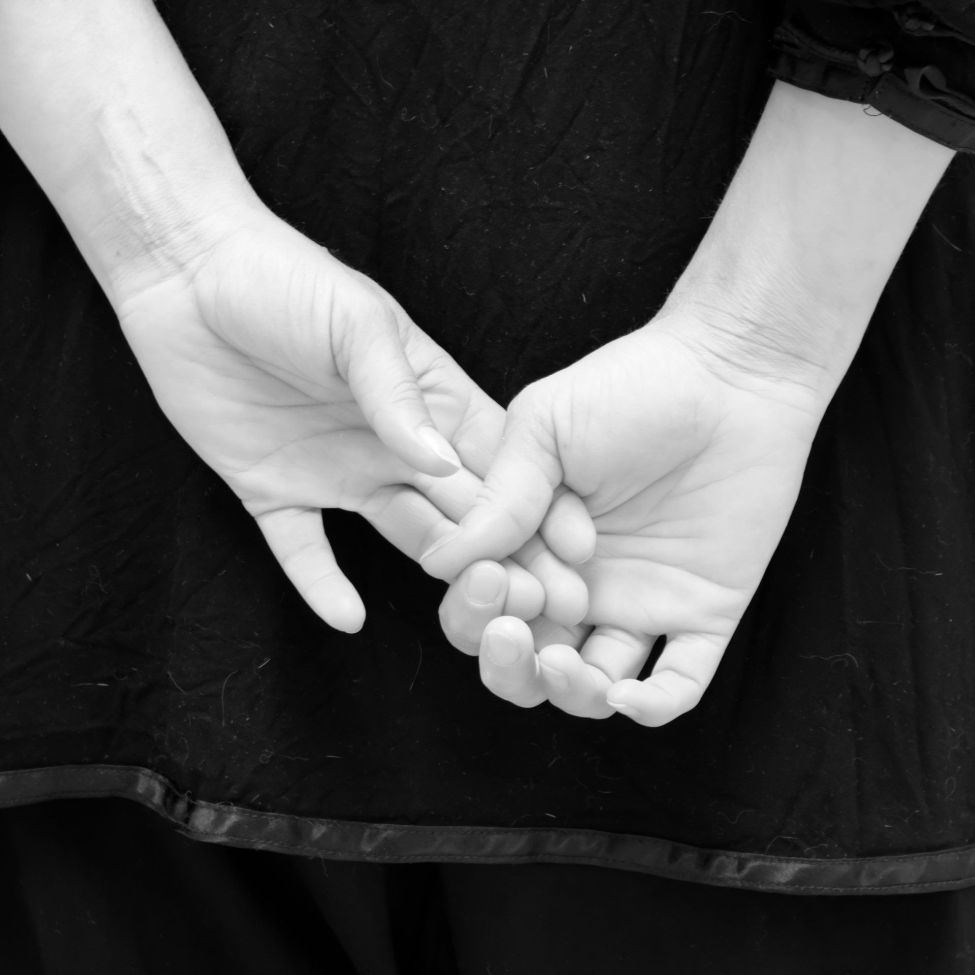Una foto in bianco e nero di una donna che tiene le mani dietro la schiena