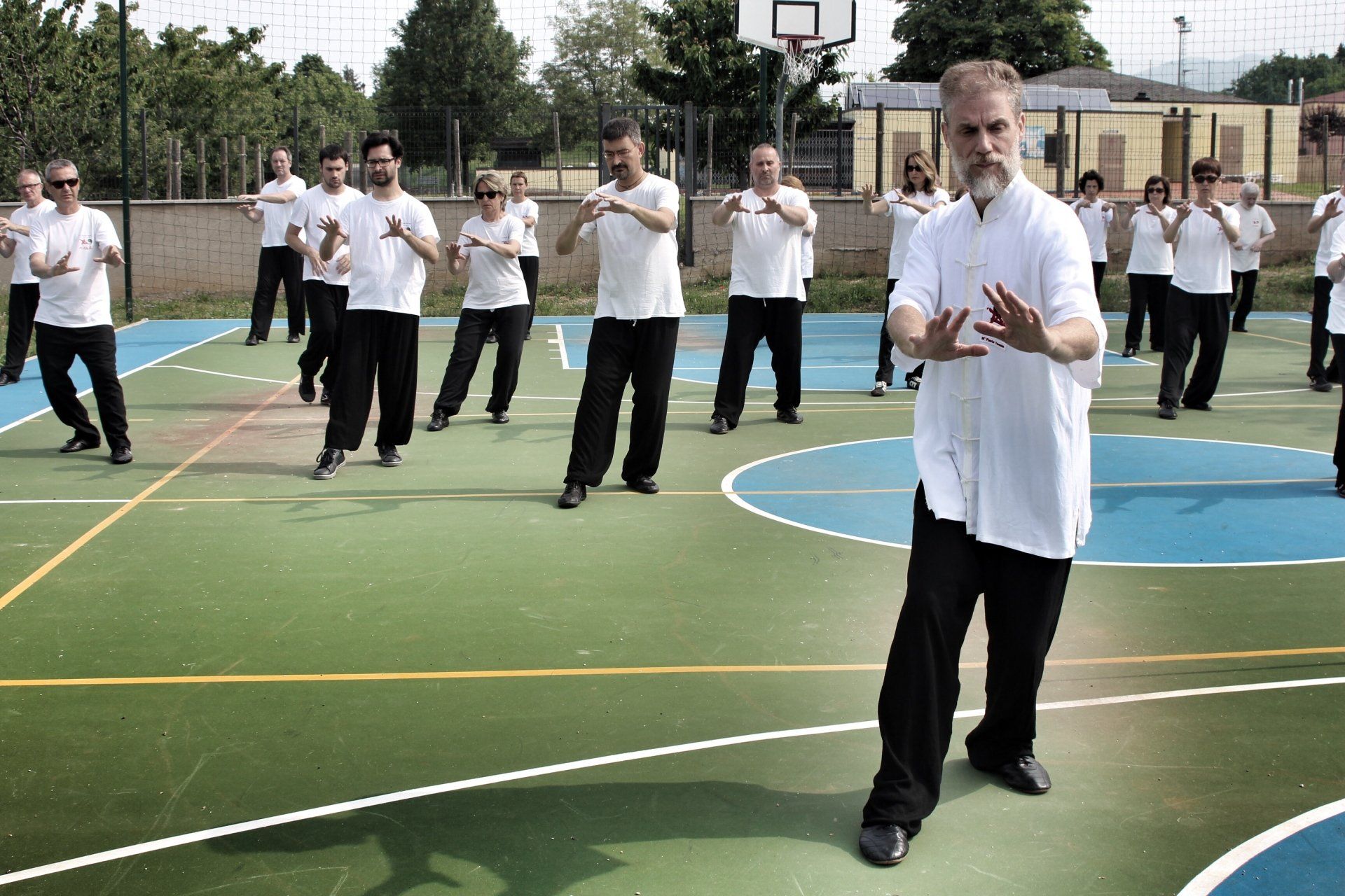 Un gruppo di uomini pratica arti marziali su un campo da basket