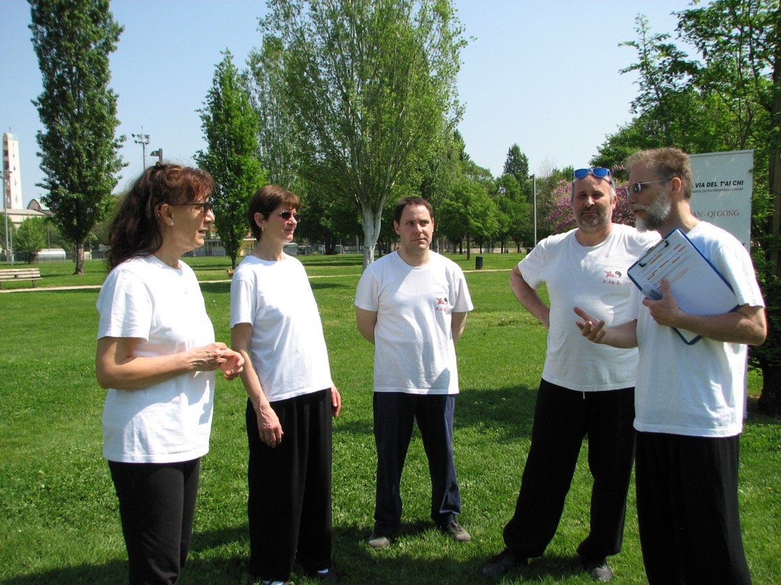 Un gruppo di persone in camicia bianca è in piedi in un parco