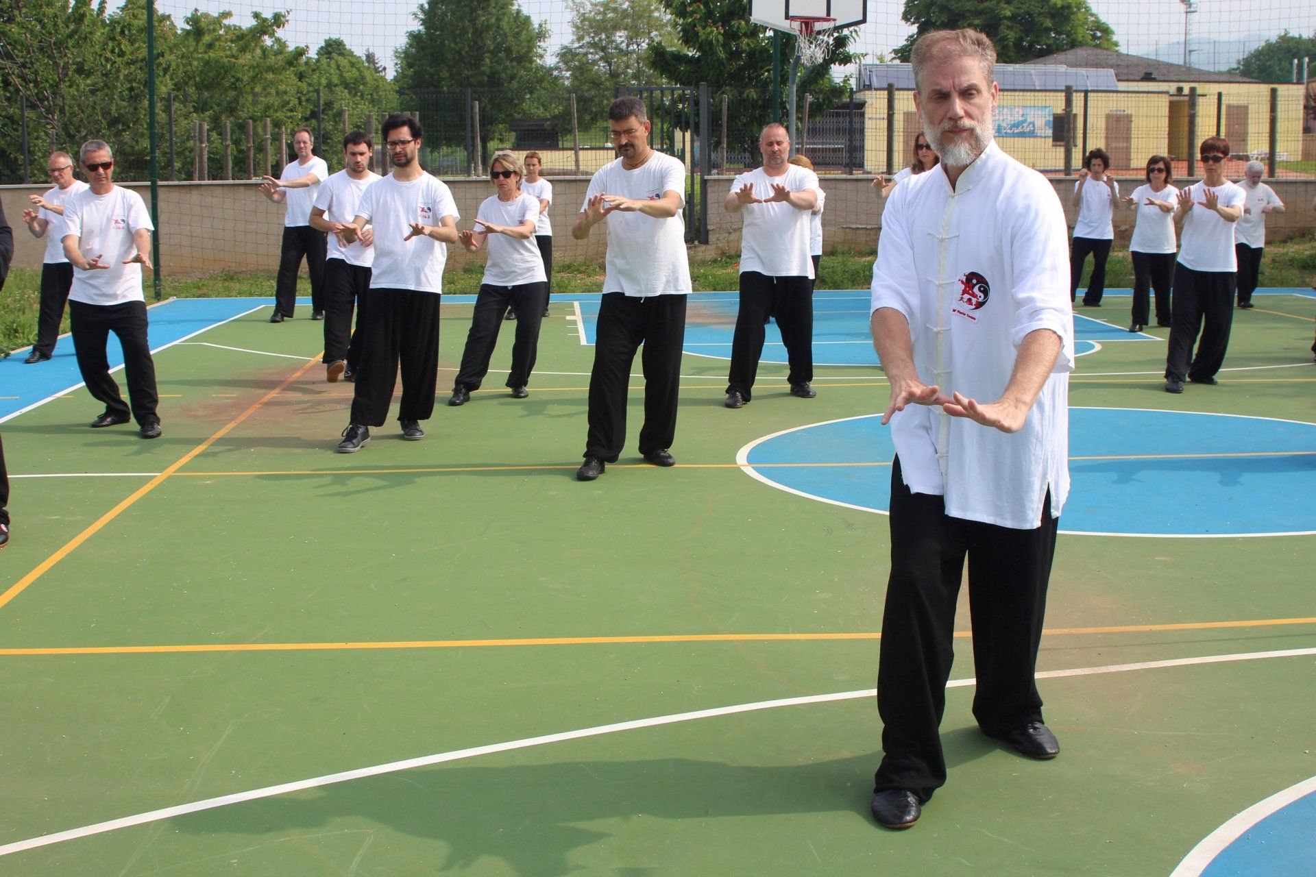 Un gruppo di uomini pratica arti marziali su un campo da basket