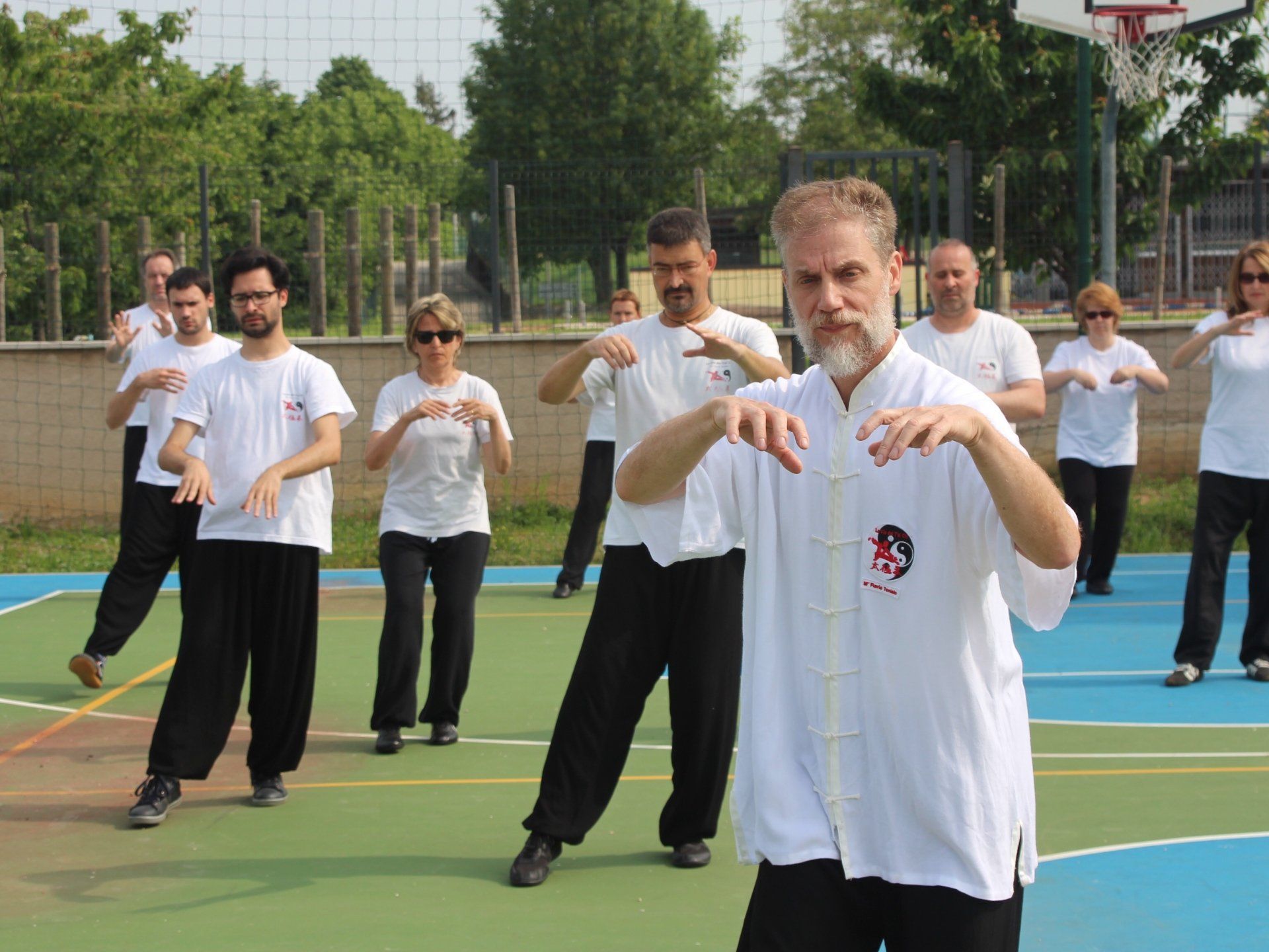Un gruppo di persone pratica arti marziali su un campo da basket.