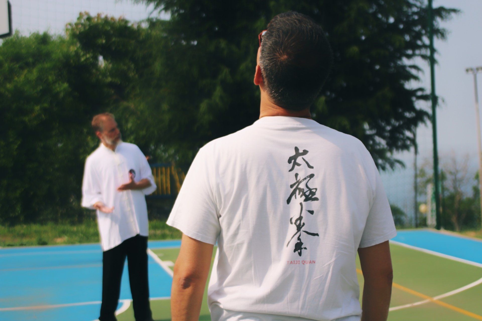 Un uomo che indossa una camicia bianca con scritte cinesi sul retro