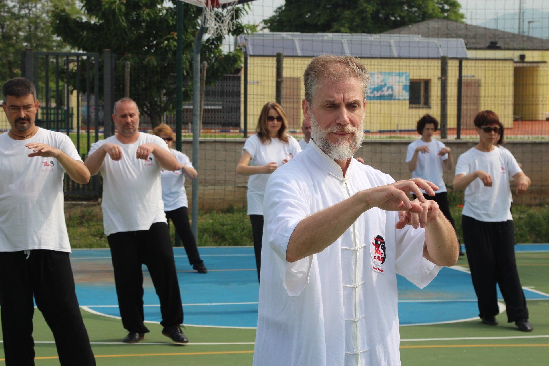 Un gruppo di persone pratica arti marziali su un campo da basket.
