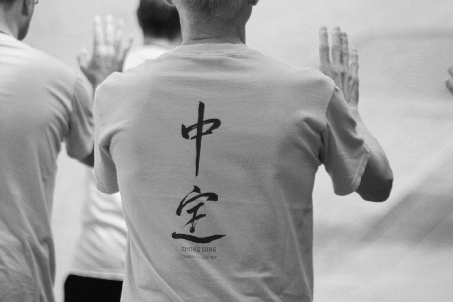 Una persona che indossa una camicia bianca con scritte cinesi sul retro
