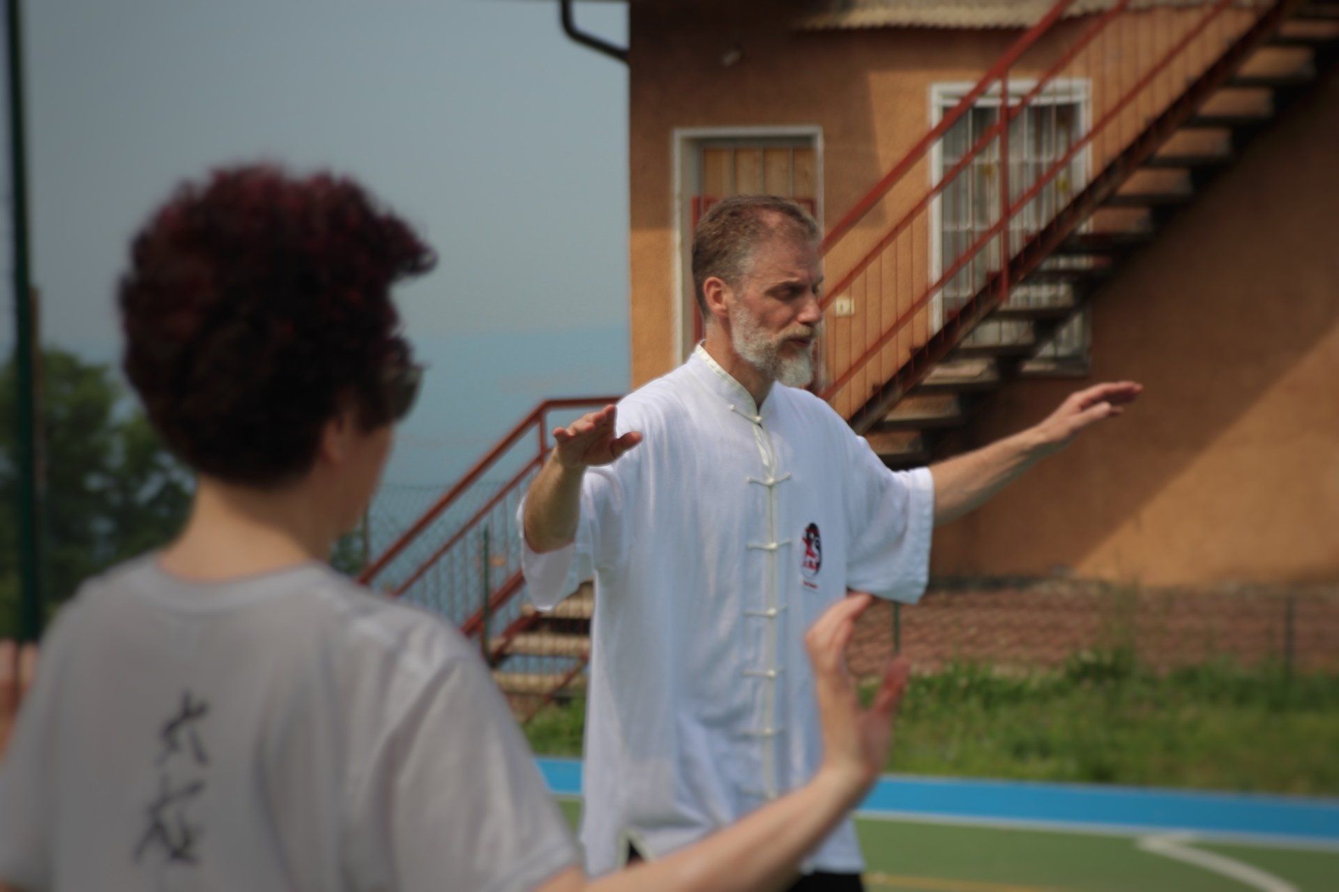Un uomo e una donna praticano arti marziali davanti a un edificio con scale