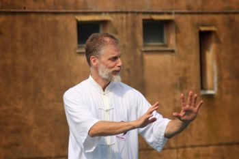 Un uomo con la barba pratica le arti marziali davanti a un edificio.