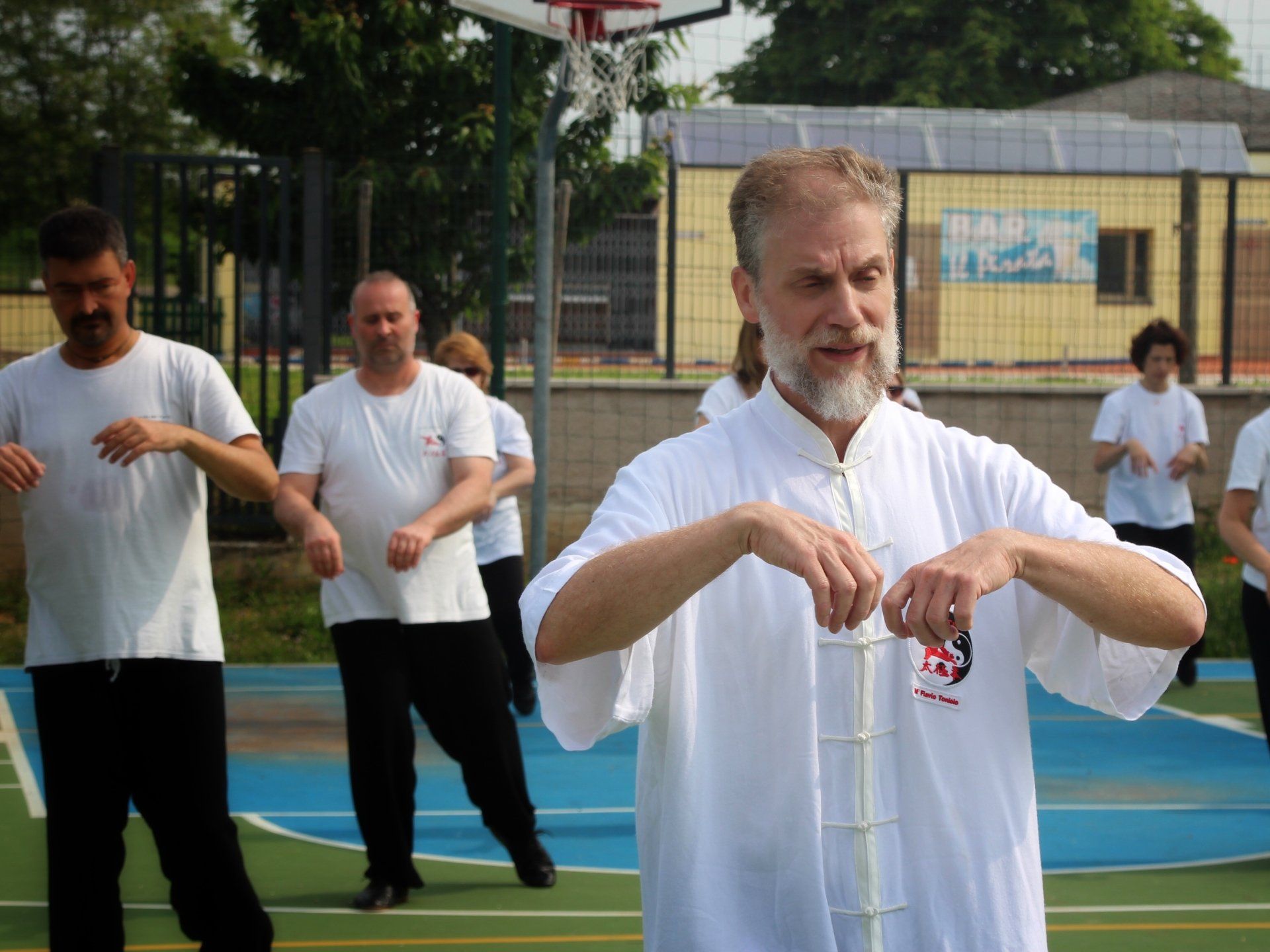 Un gruppo di uomini pratica arti marziali su un campo da basket.