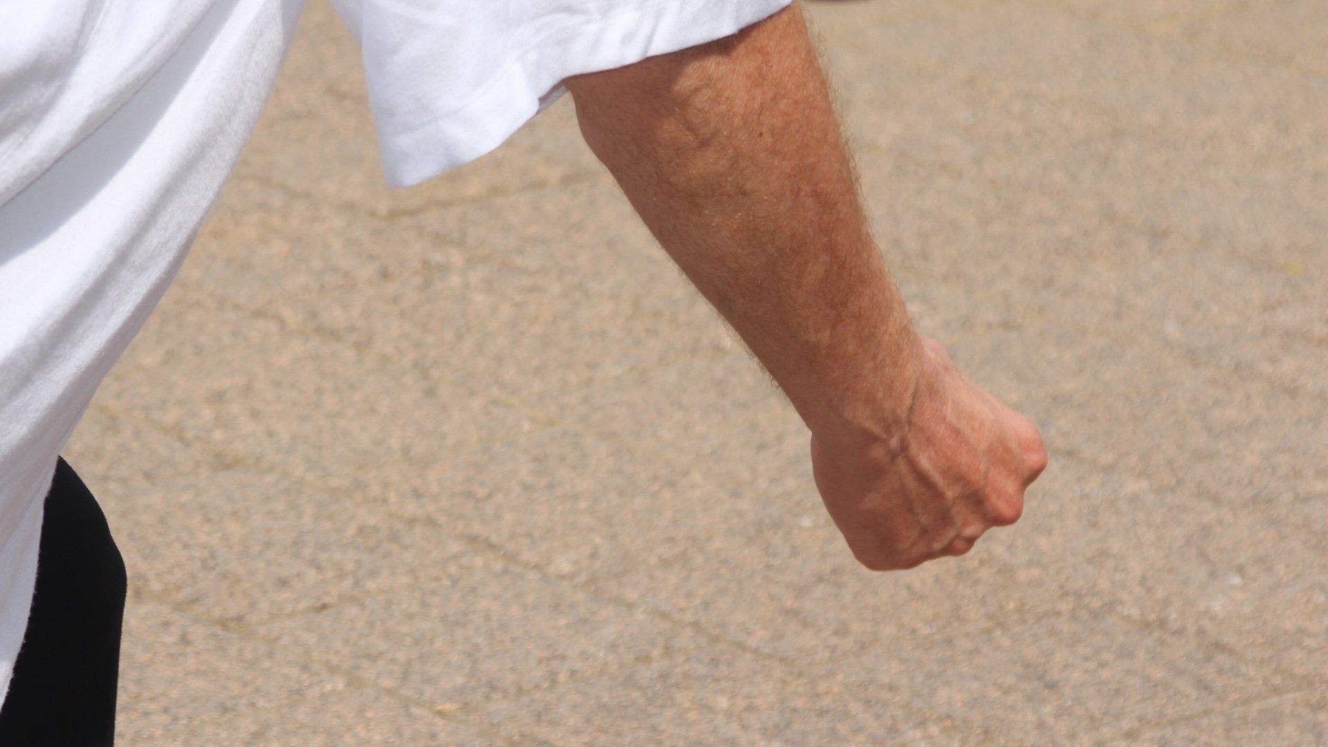 Un uomo in camicia bianca ha il pugno in aria