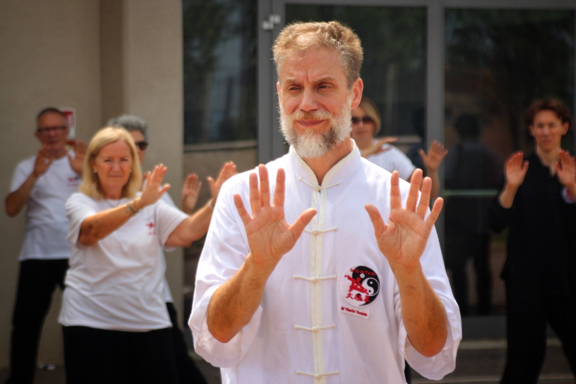 Un uomo con la barba è in piedi di fronte a un gruppo di persone.