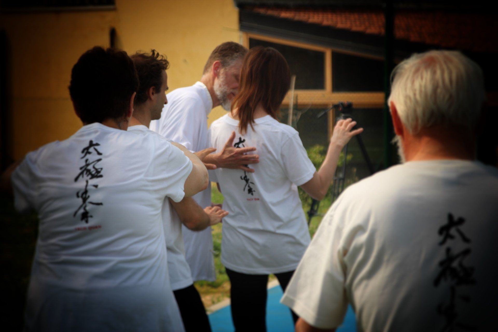 Un gruppo di persone che indossano camicie bianche con scritte cinesi sopra