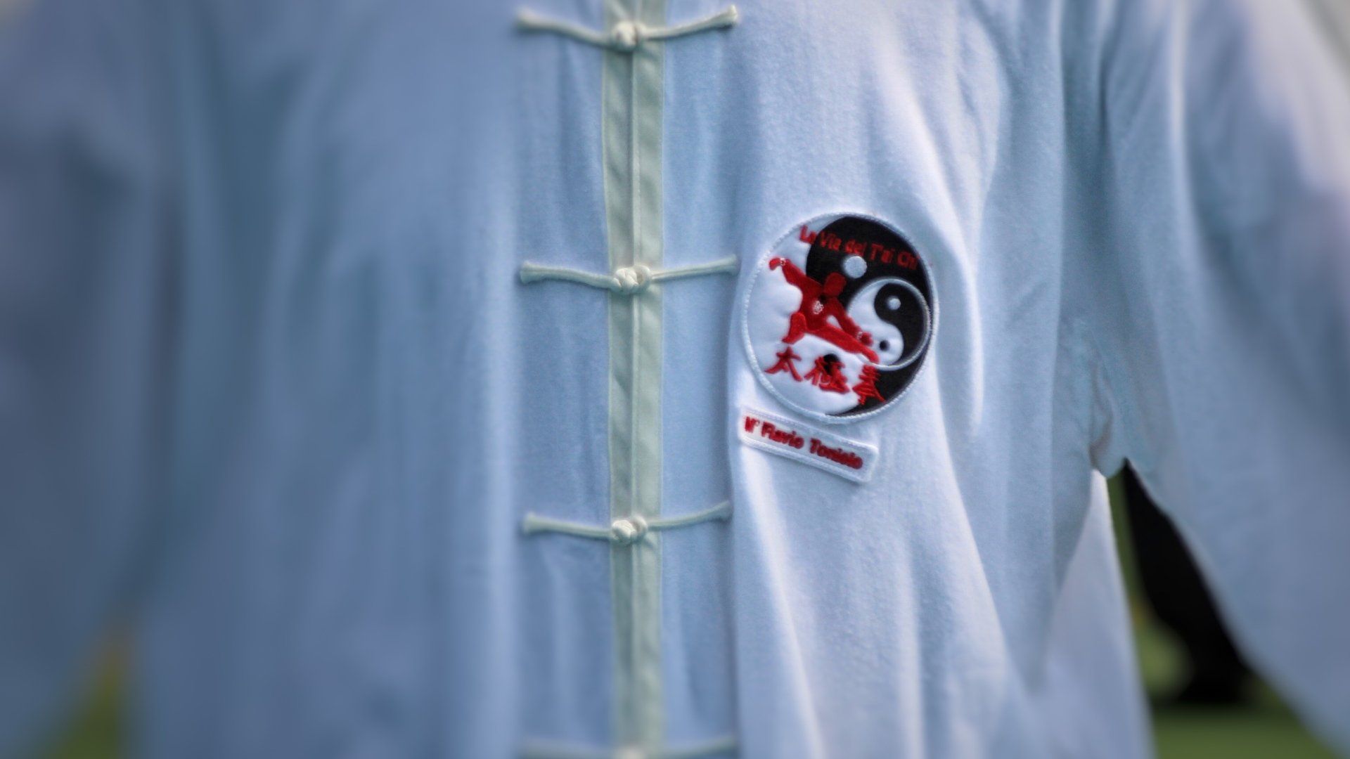 Una persona che indossa una camicia bianca con sopra il simbolo yin yang.