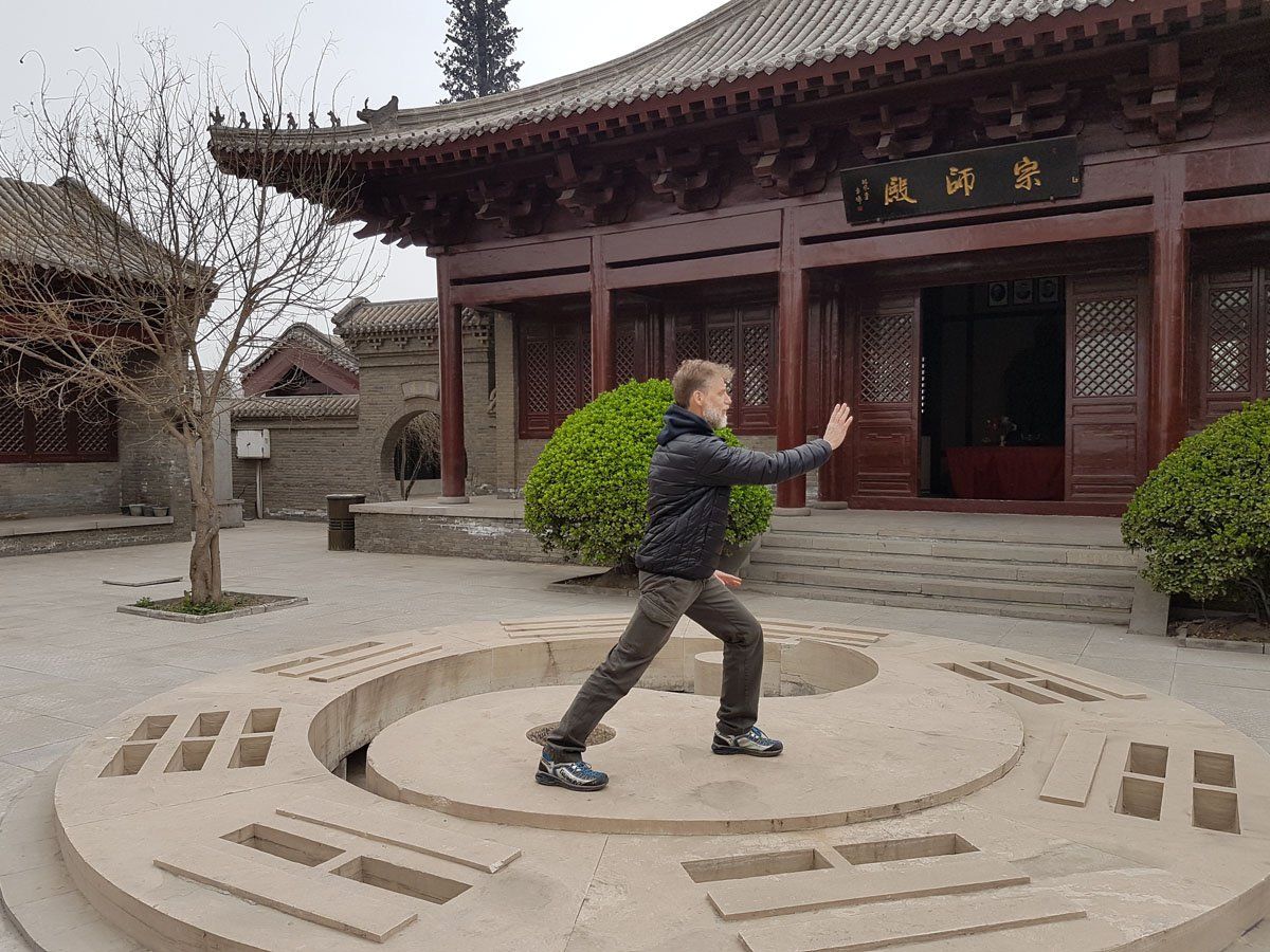 Un uomo pratica arti marziali davanti a un edificio.
