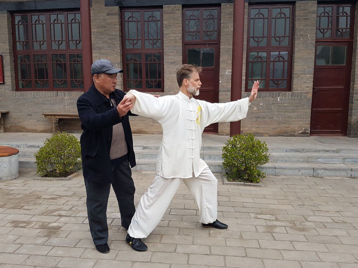 Due uomini praticano arti marziali davanti a un edificio.