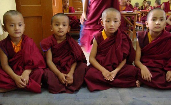 Un gruppo di giovani monaci è seduto per terra