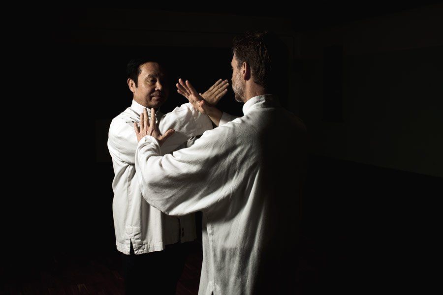 Due uomini praticano le arti marziali davanti a uno specchio.