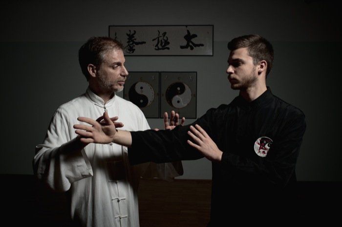 Due uomini praticano le arti marziali in una stanza buia