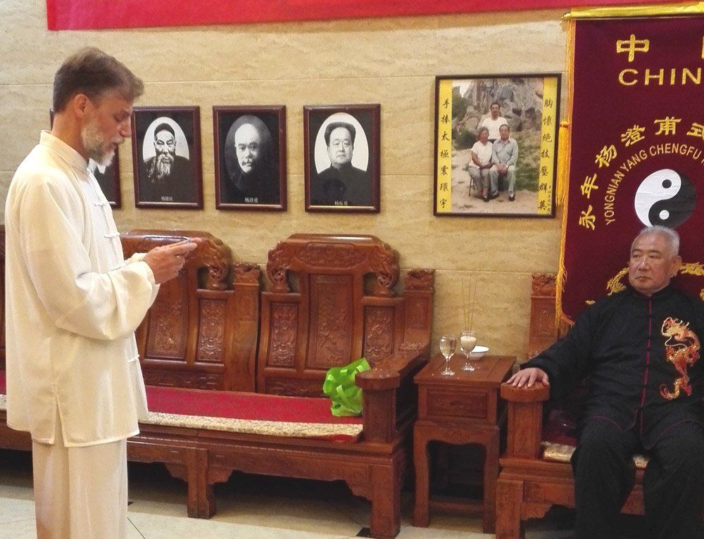 Due uomini sono seduti su delle sedie davanti a un muro con dei quadri sopra