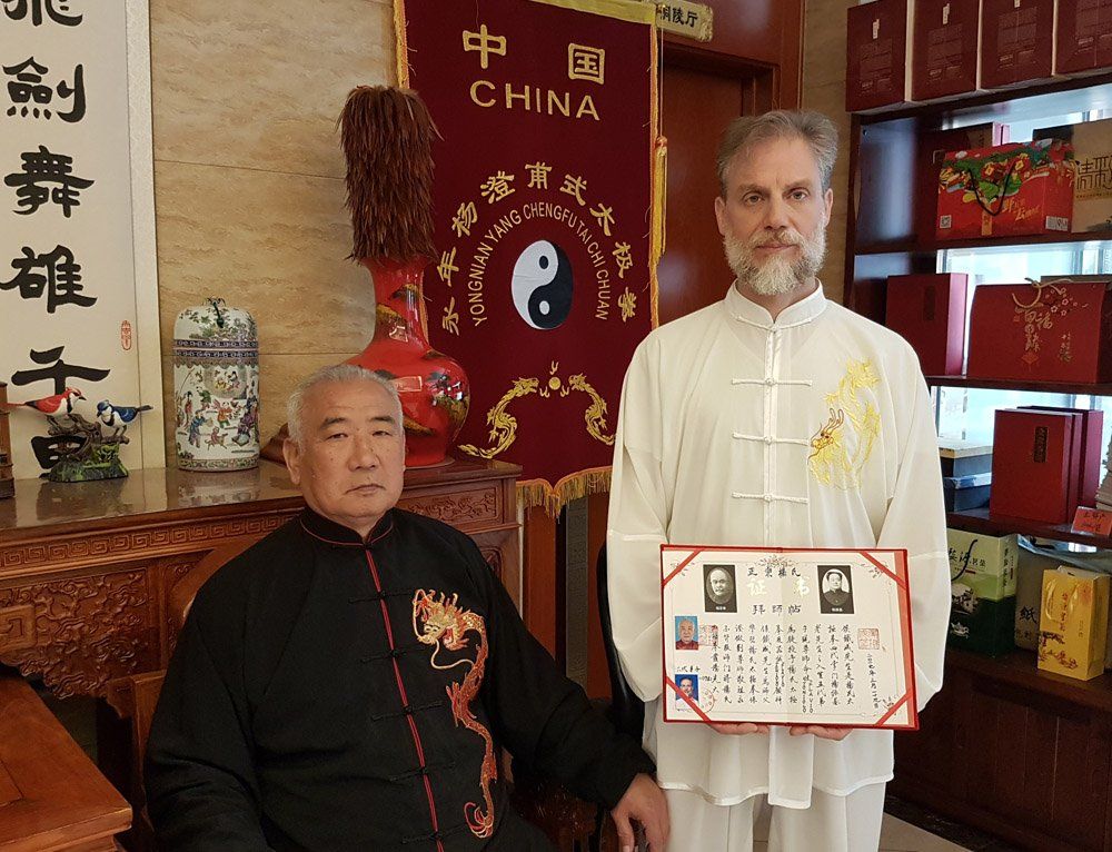 Due uomini sono in piedi davanti a uno striscione cinese