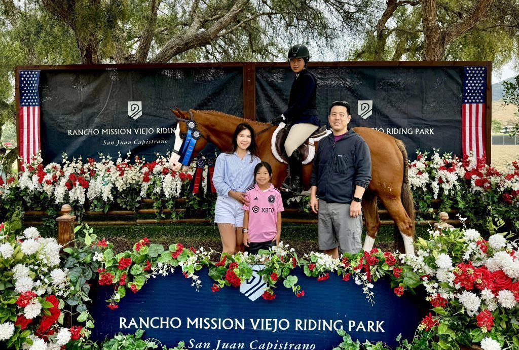 A family is posing for a picture with a horse.