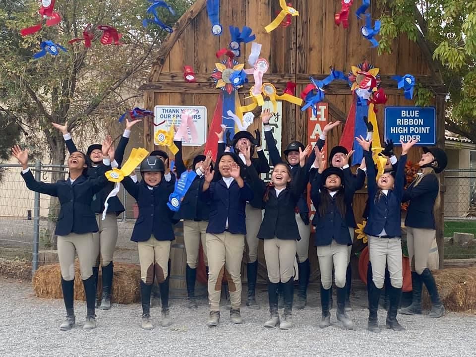 A group of people are posing for a picture with balloons in the air.