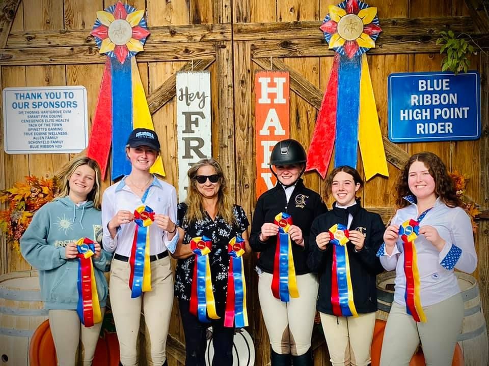 A group of people standing next to each other holding ribbons.