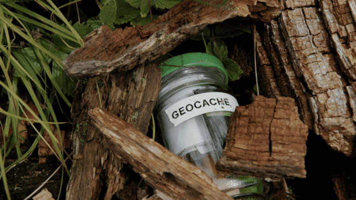 Kirkas muovinen astia, jossa luki "GEOCACHE", oli sään kuluttaman puuhirren ontelossa.