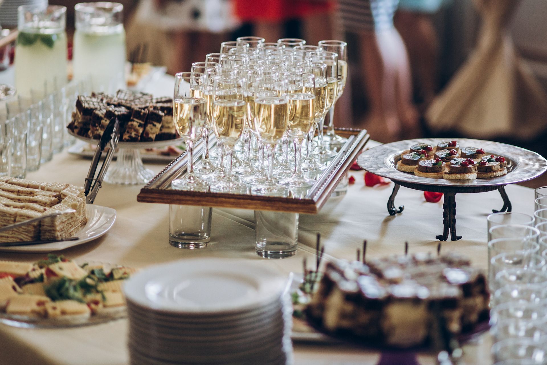 Buffet table with champagne, cakes, and appetizers for a celebration.
