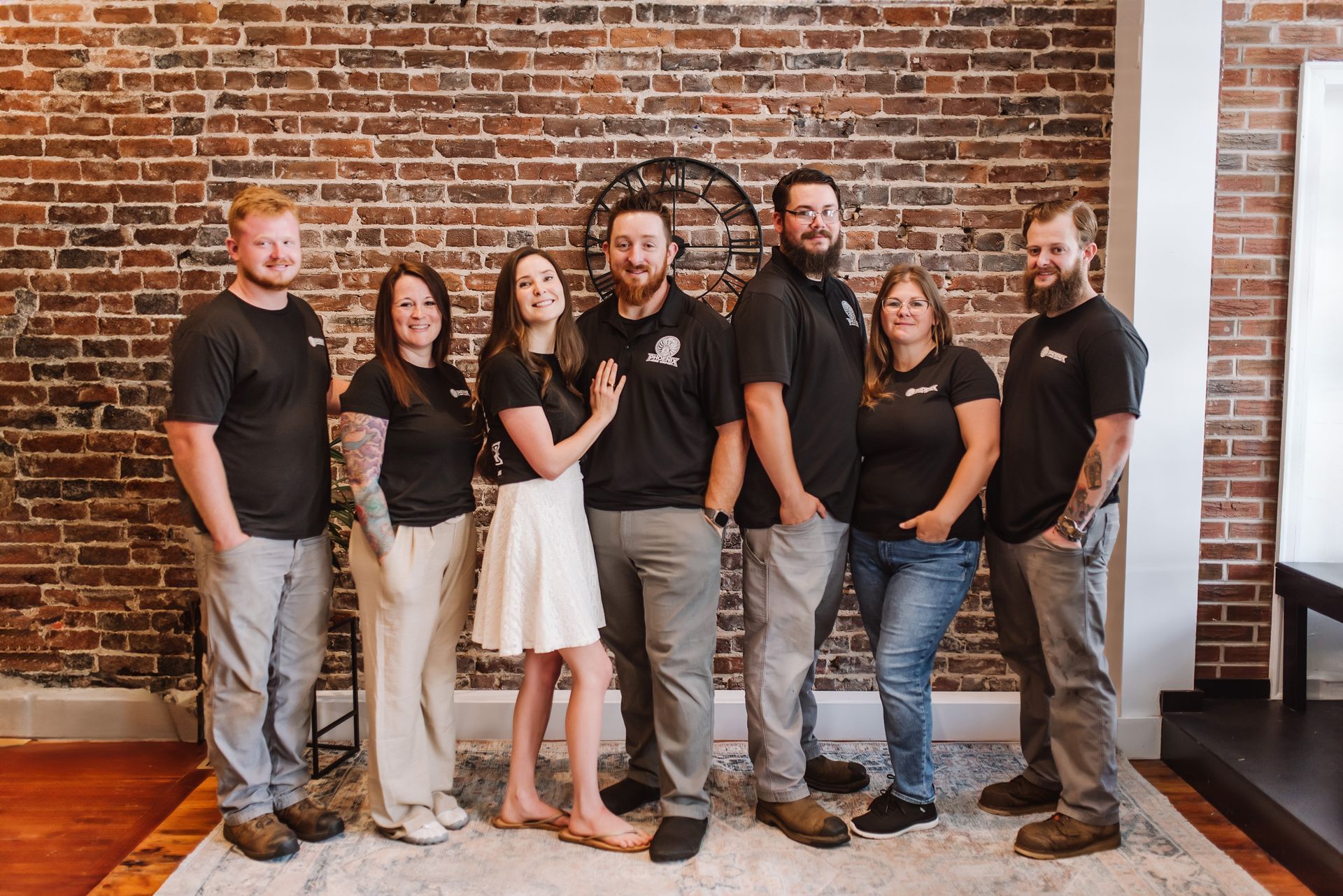 Family in a bright room: Father holding baby, mother smiles. Air conditioner above window.
