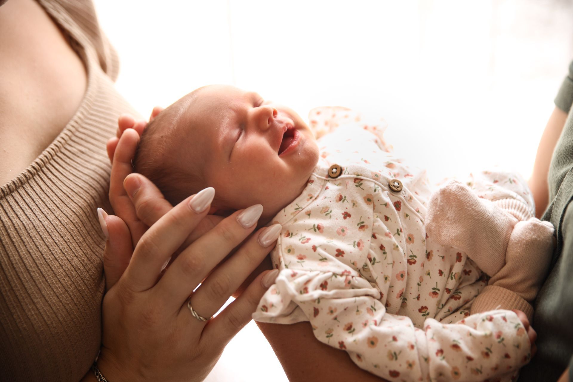 Een pasgeboren baby slaapt in de armen van een ouder. Lifestyle newborn fotograaf Zuidland. Lifestyle newborn fotograaf.