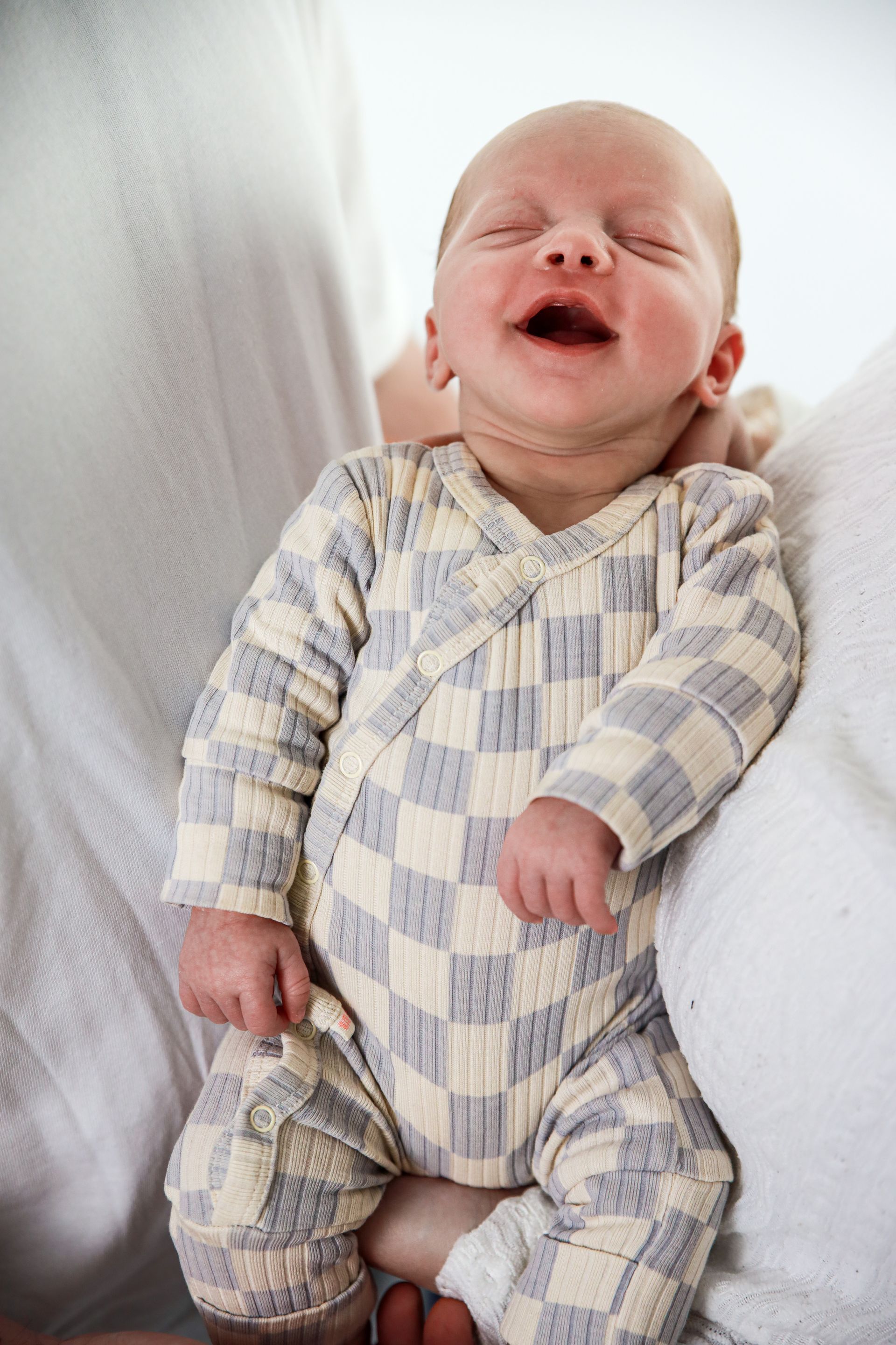 Een slapende baby met lach. Studio fotoshoot Zuidland. Newborn studio fotoshoot. Newborn studio fotoshoot Spijkenisse.