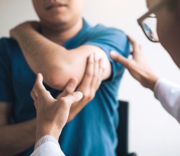 A Chiropractor Checking A Man's Arm — Anoka, MN — North Country Chiropractic