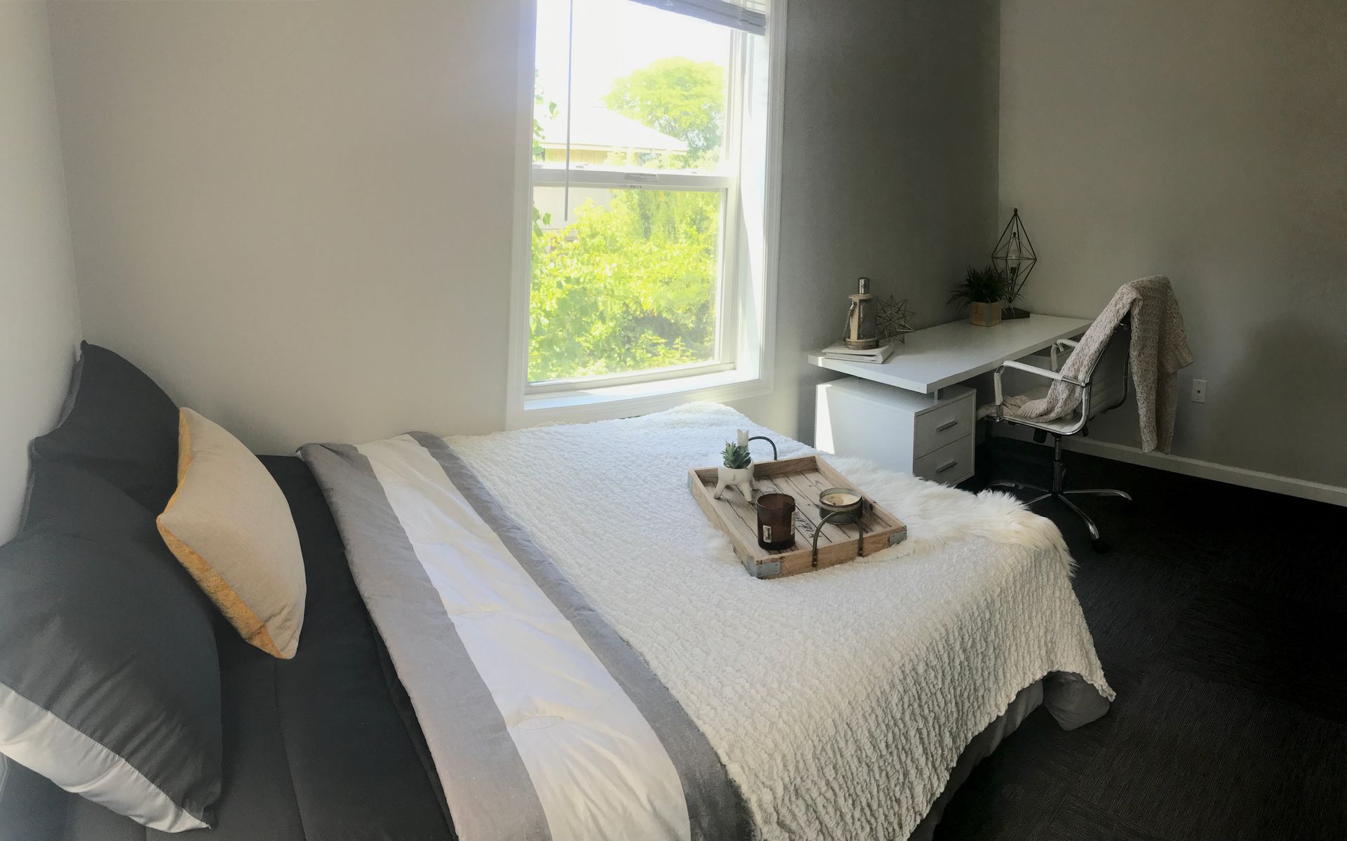 a bedroom with a bed a desk and a window