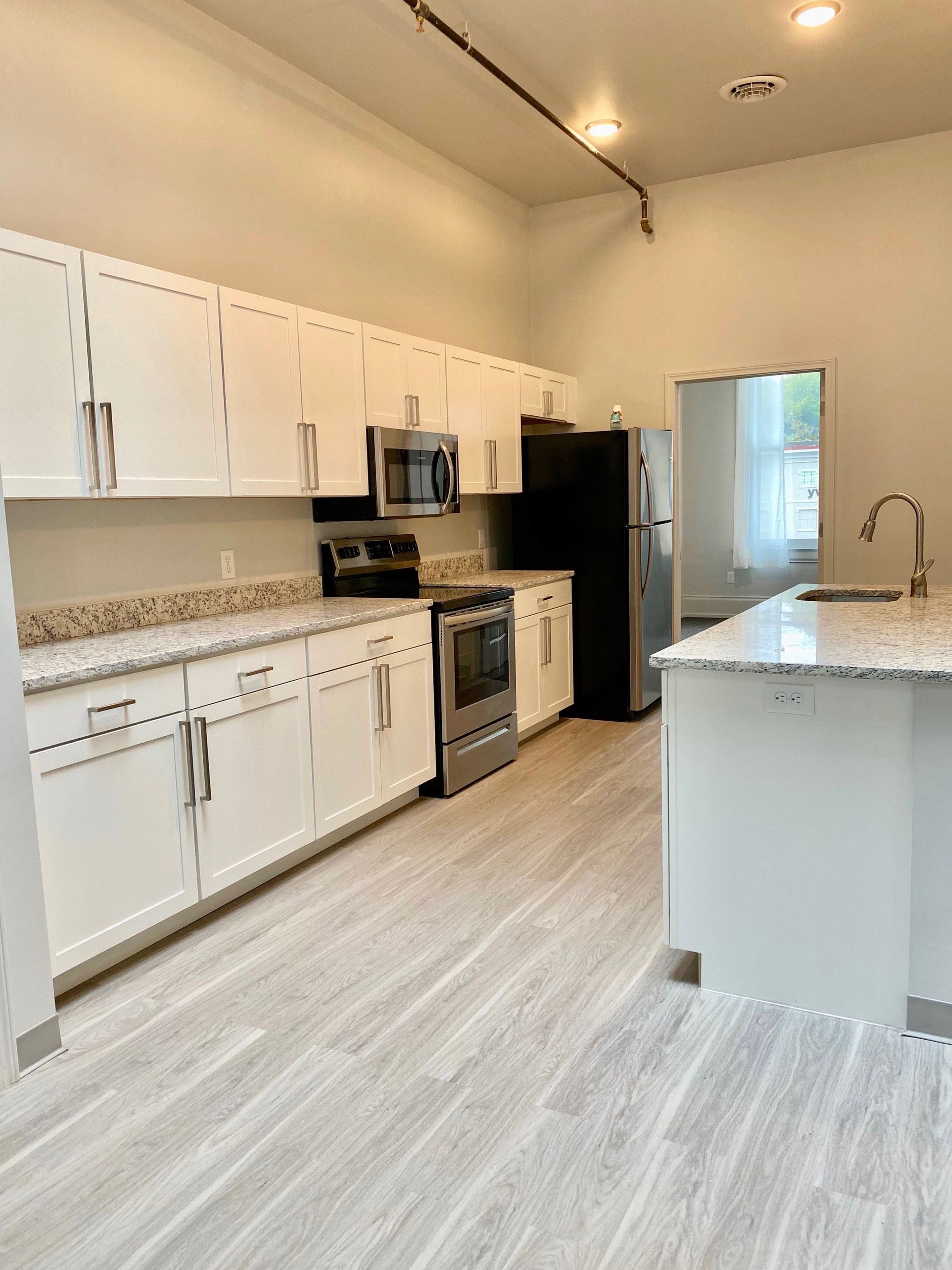 a kitchen with white cabinets and stainless steel appliances
