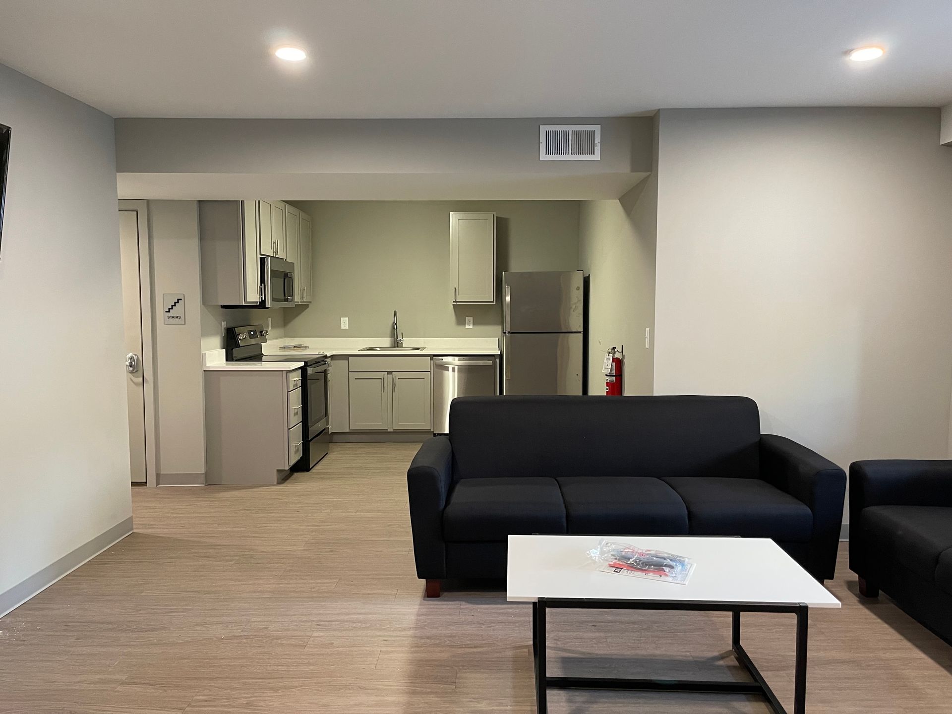 a living room with a black couch and a white coffee table