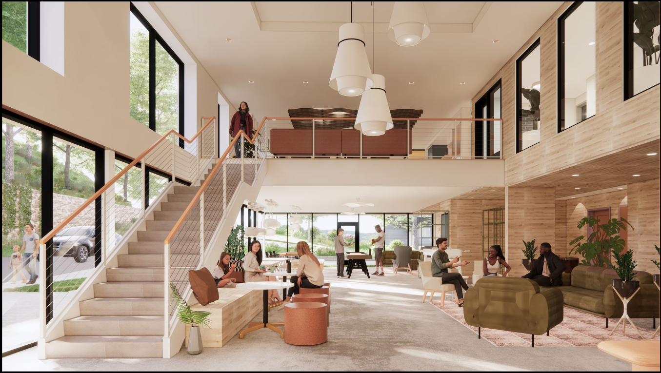 Interior of a modern, open-plan office with people. Sunlight streams through large windows. A staircase leads to an upper level.