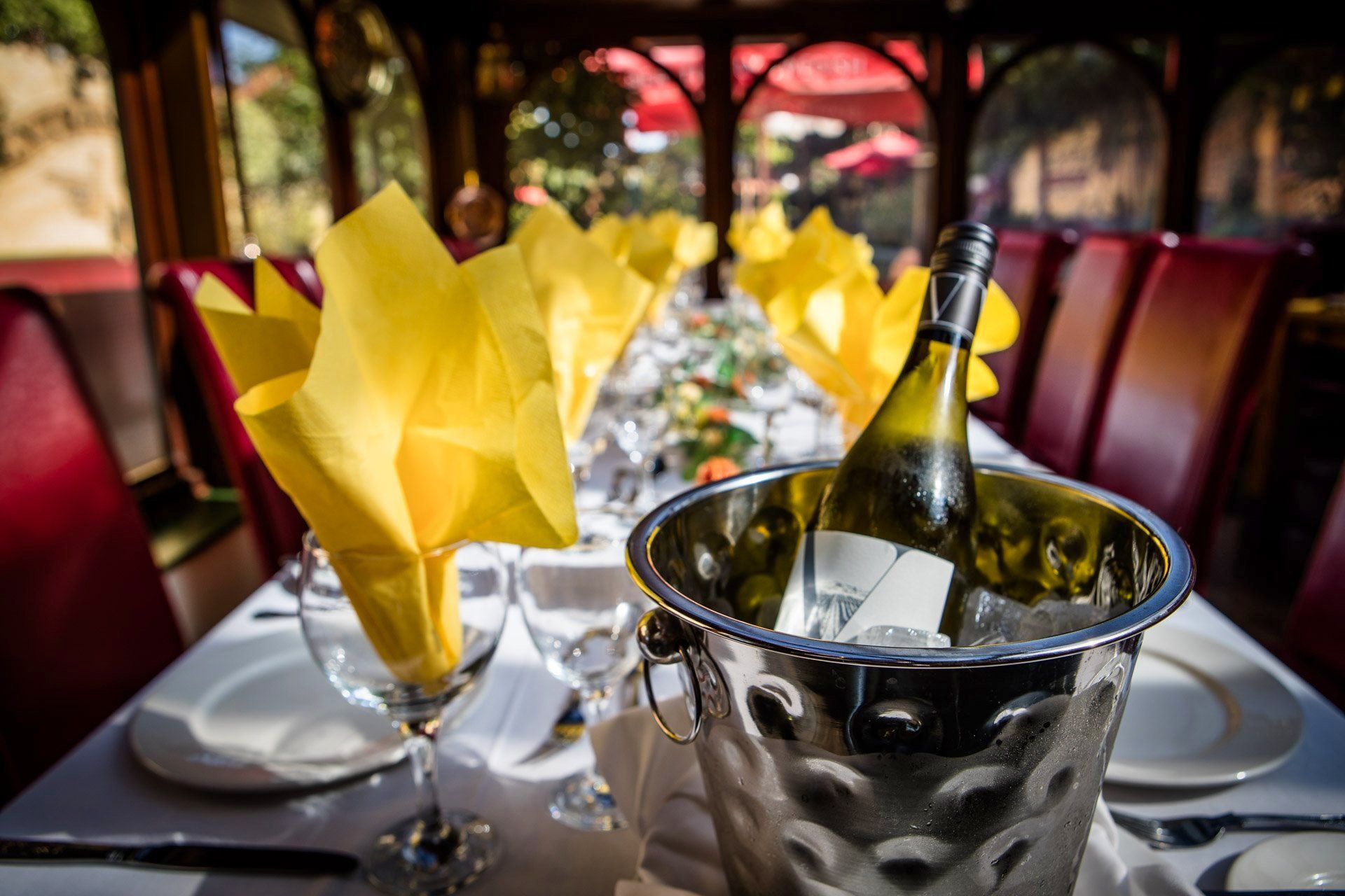 Table setting with wine bucket and yellow napkins.