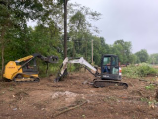 Excavator clearing land