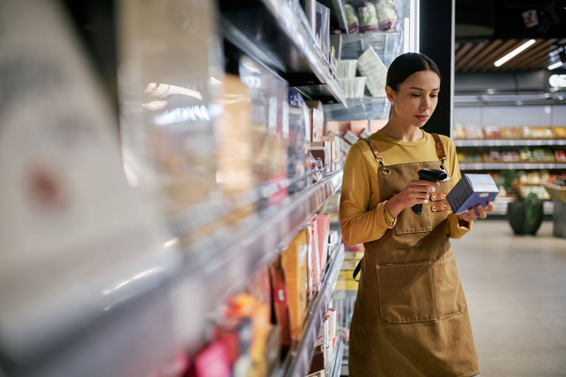 Une femme scanne un produit dans une épicerie.
