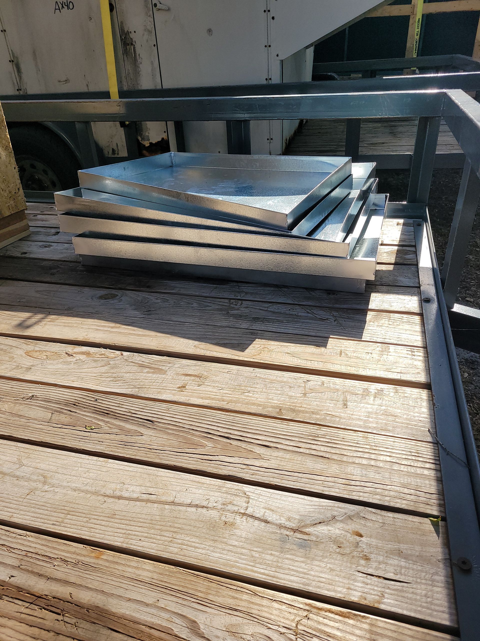 Stack of metal squares on wooden trailer bed.