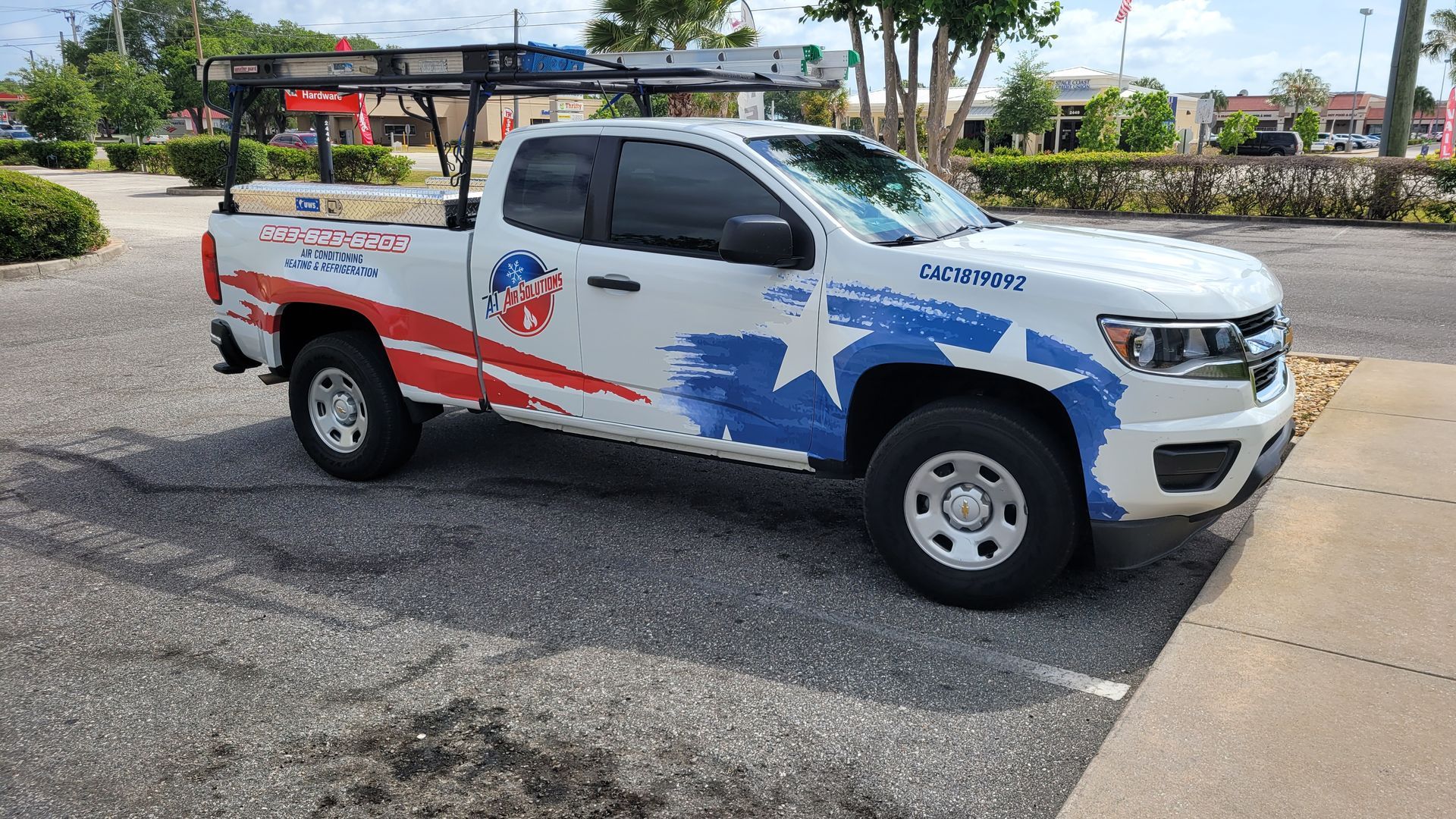 White work truck with red and blue patriotic graphics parked on asphalt.