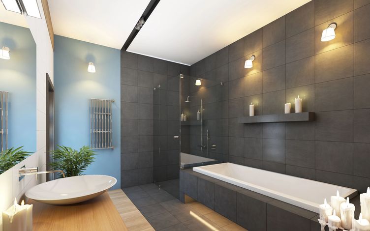 Bagno moderno con piastrelle grigie, vasca freestanding, cabina doccia e mobile lavabo accanto a una finestra.