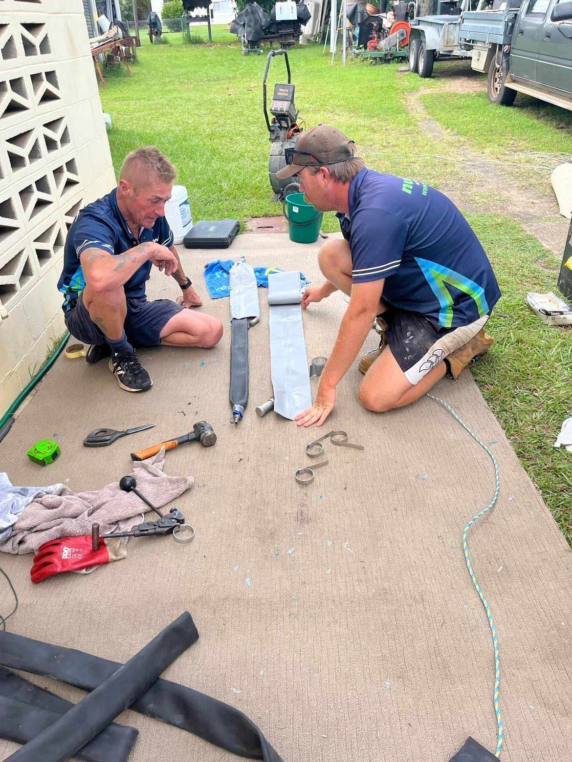 Two Men Repairing Equipment Outdoors — Nuflow Wide Bay in Bundaberg South, QLD