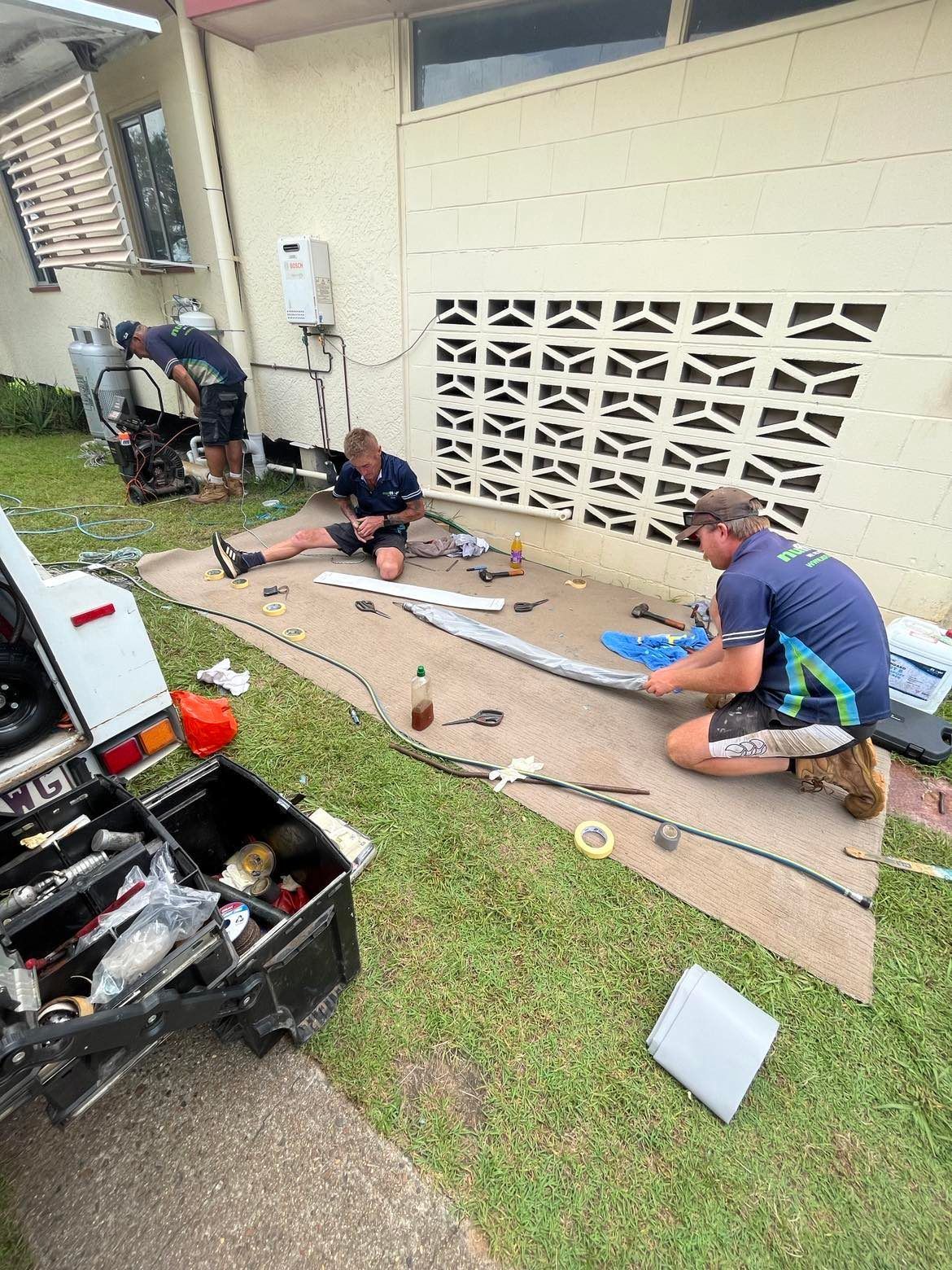 People Repairing a Vehicle Part on A Concrete Slab — Nuflow Wide Bay in South Kolan, QLD