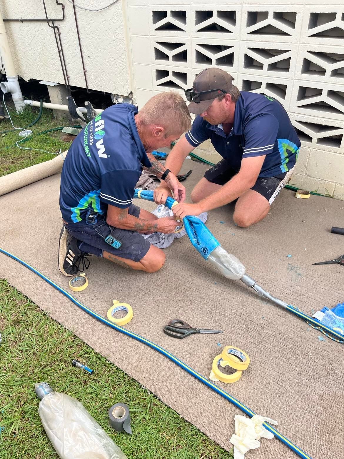 Two Men Repair a Hose on A Carpet — Nuflow Wide Bay in 1770, QLD