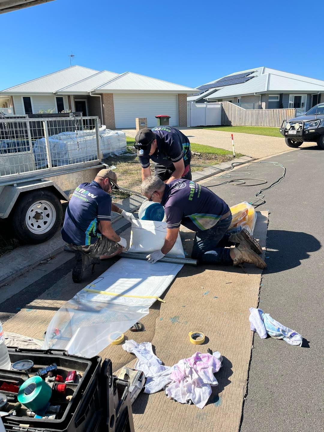 A Workers Install a White Object on A Sidewalk — Nuflow Wide Bay in Woodgate, QLD