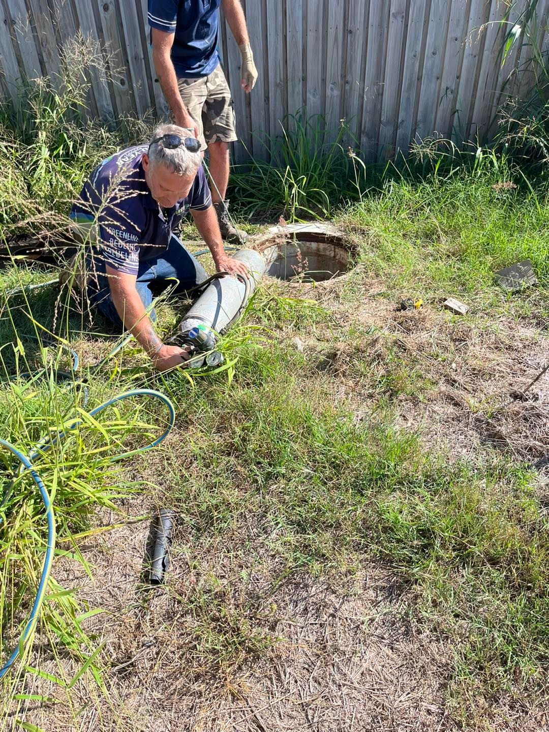 Two Men Inspecting a Well in A Grassy Yard — Nuflow Wide Bay in Childers, QLD