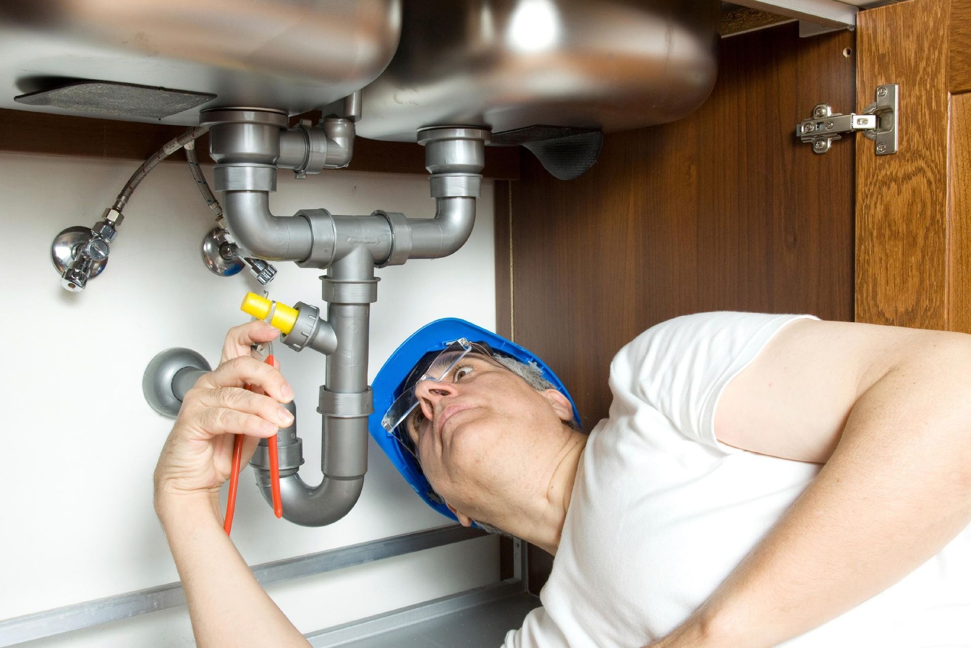 A Plumber Working Under a Sink — Nuflow Wide Bay in Bargara, QLD